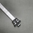 The second carved cap of the anklet with its slot for the pin, on the flat snake chain.