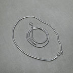 The pair of round snake chain silver anklets with both spring ring clasps showing.
