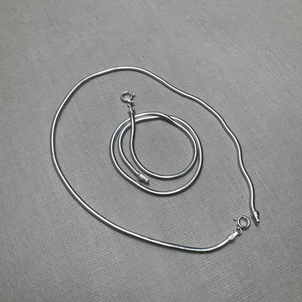 The pair of round snake chain silver payal with both spring ring clasps showing.