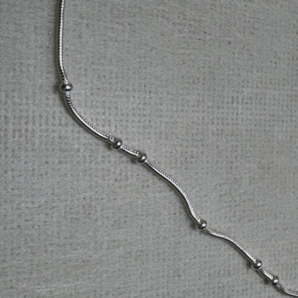 Close-up of the snake chain and the evenly spaced silver beads of the payal pair.