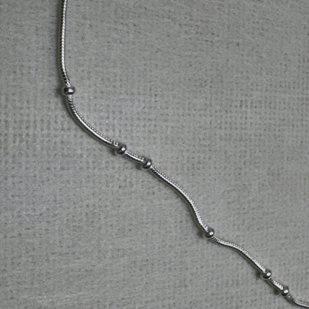 Close-up of the snake chain and the evenly spaced silver beads of the payal pair.