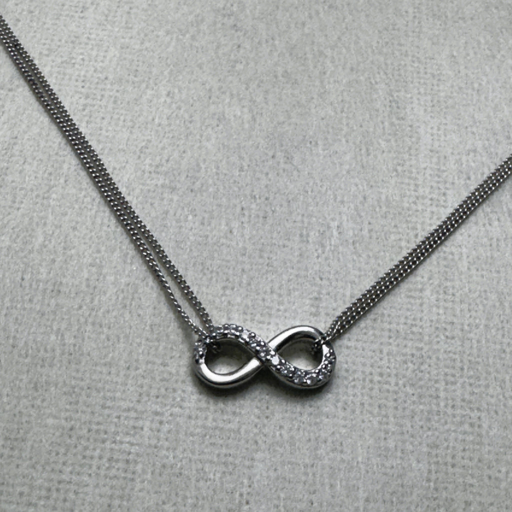 Sterling silver anklet with a love knot half set with American Diamonds, on a double curb chain.