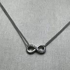 Sterling silver anklet with a love knot half set with American Diamonds, on a double curb chain.