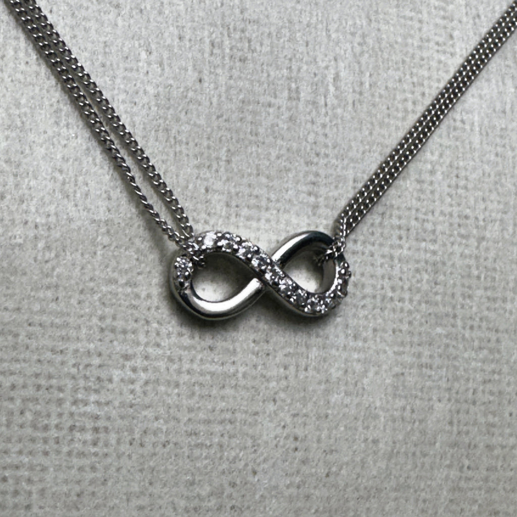Close-up of the love knot, one loop pave set with American Diamonds and the other polished silver.
