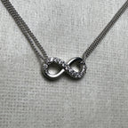 Close-up of the love knot, one loop pave set with American Diamonds and the other polished silver.