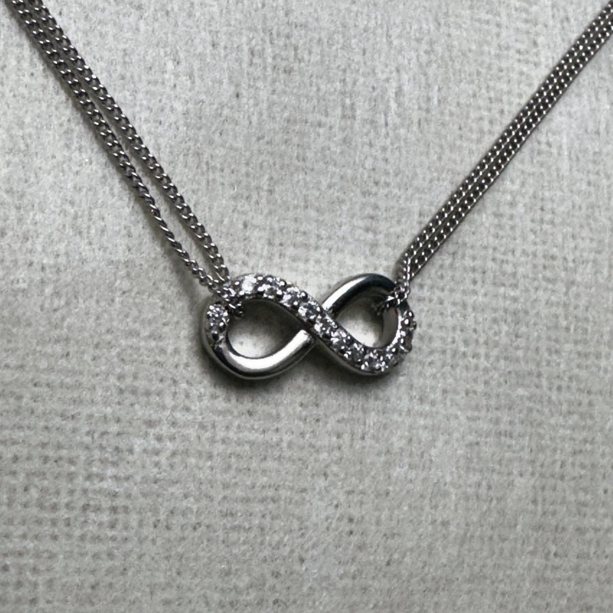 Close-up of the love knot, one loop pave set with American Diamonds and the other polished silver.