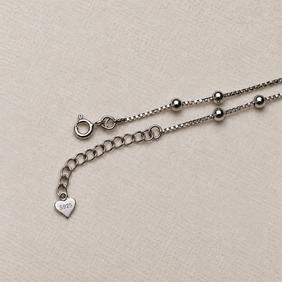 The spring ring clasp, extender chain and heart tag of the American Diamond drop anklet.