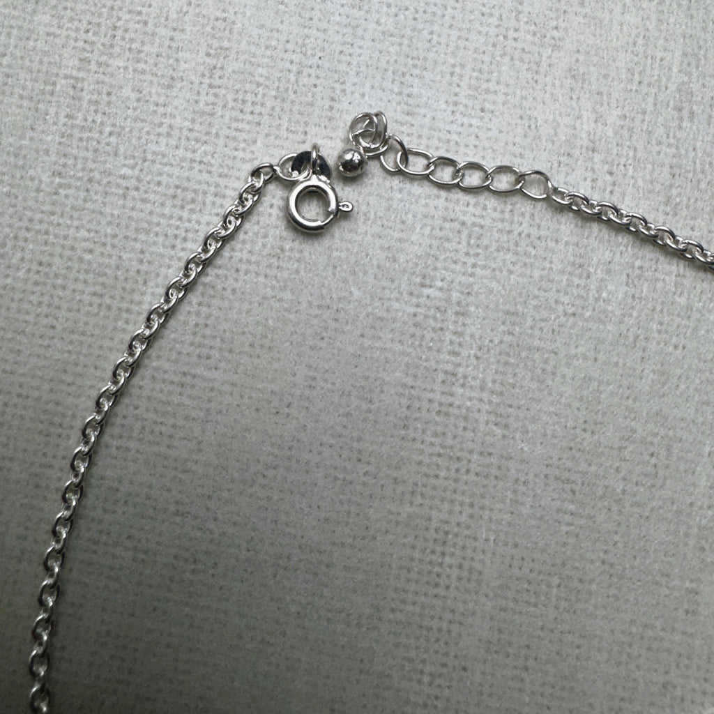 The spring ring clasp and extender chain of the emoji charm silver anklet.