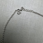 The spring ring clasp and extender chain of the emoji charm silver anklet.