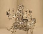 Close view of the back of the silver Durga idol, showing the disc and the cut work on the saddle cloth.