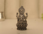 Back of the antique silver Lakshmi idol, showing the fluted disc behind her head and the lotus petals below.