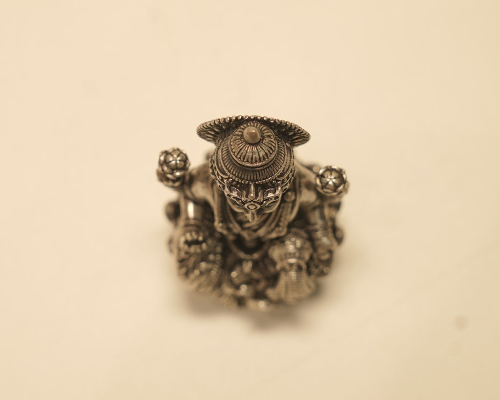 Looking down on the antique silver Lakshmi idol, showing the crown and the spread of the lotus.