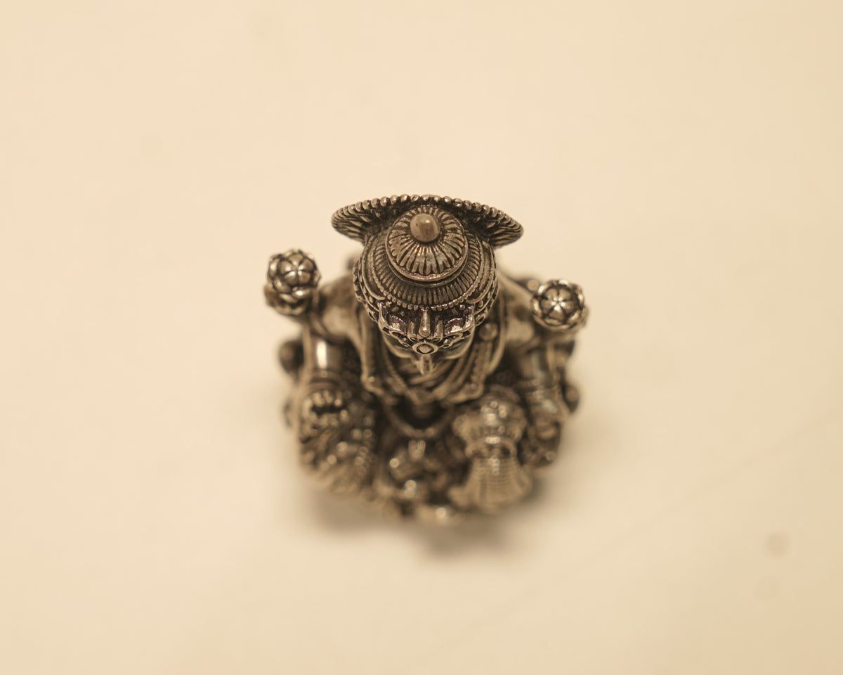 Looking down on the antique silver Lakshmi idol, showing the crown and the spread of the lotus.