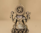 Close view of the back of the antique silver Ganesh idol, showing the swastik set in the disc.
