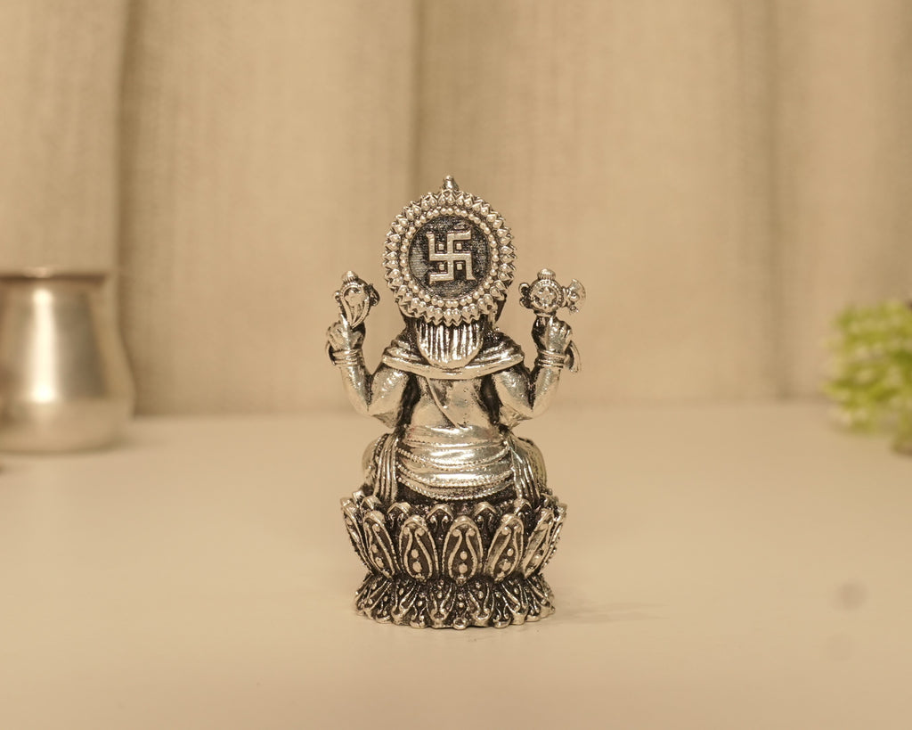 The back of the antique silver Ganesh idol at full height, showing the disc above the lotus base.