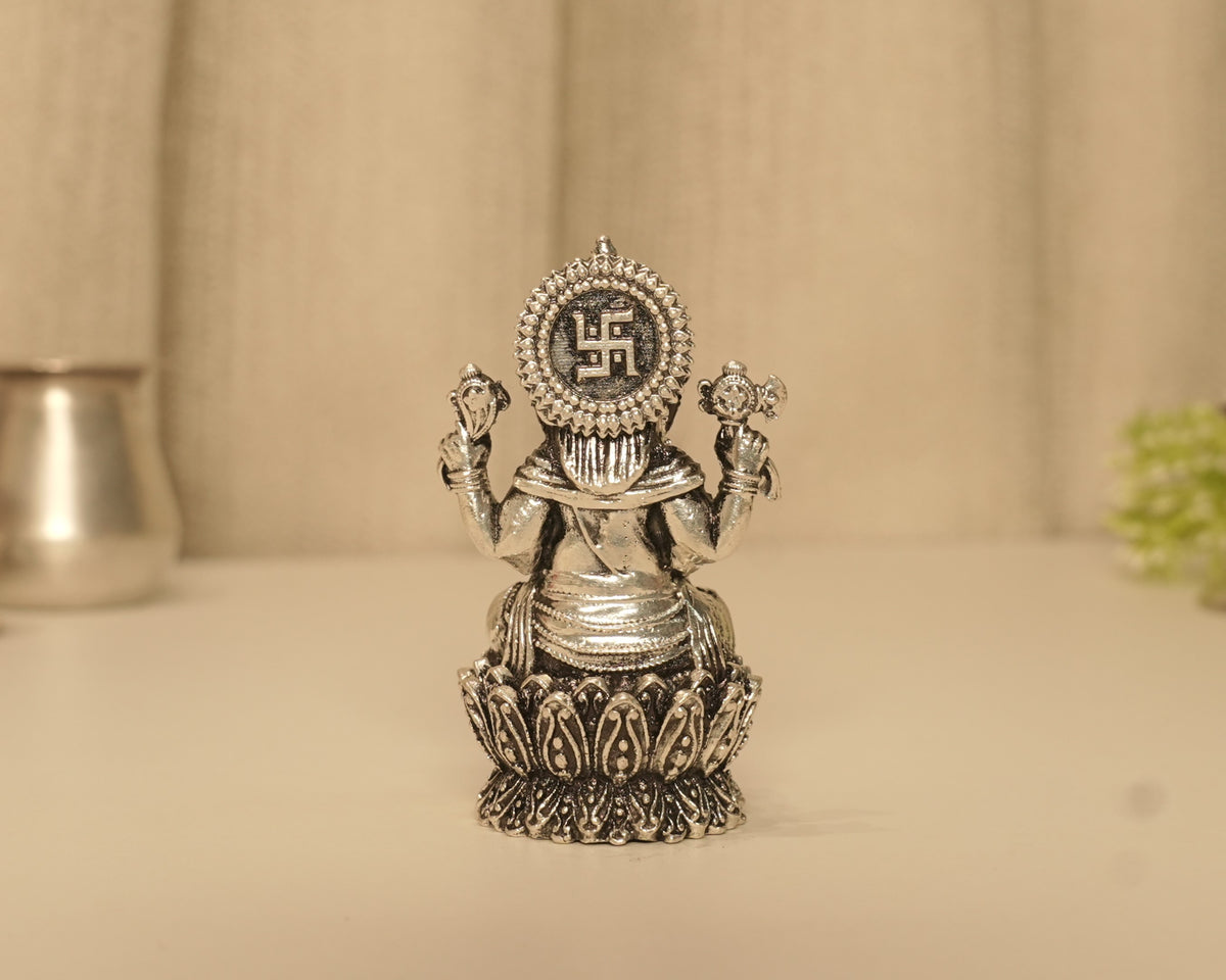 The back of the antique silver Ganesh idol at full height, showing the disc above the lotus base.