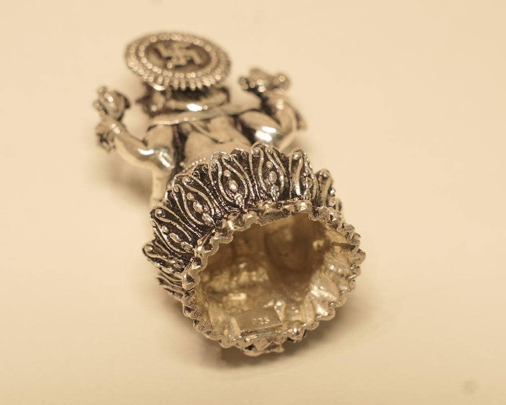 The antique silver Ganesh idol tipped to show the open underside of the lotus base.
