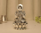 Back of the large silver Lakshmi idol, with a kalash showing through the opening in the arch.