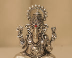 Close view of the silver Ganesh figure, the crown, the trunk and the Om marked on his palm.