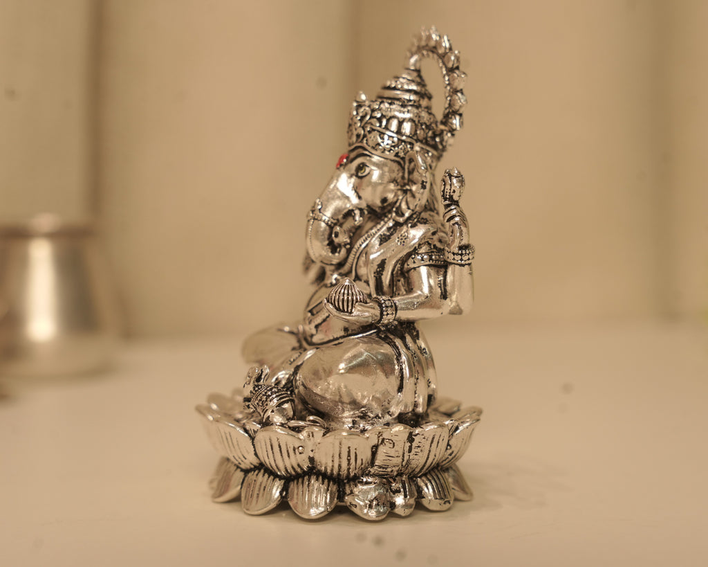Side view of the large silver Ganesh idol, showing the crown and the lotus base in profile.