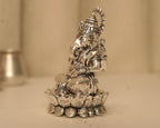 Side view of the large silver Ganesh idol, showing the crown and the lotus base in profile.