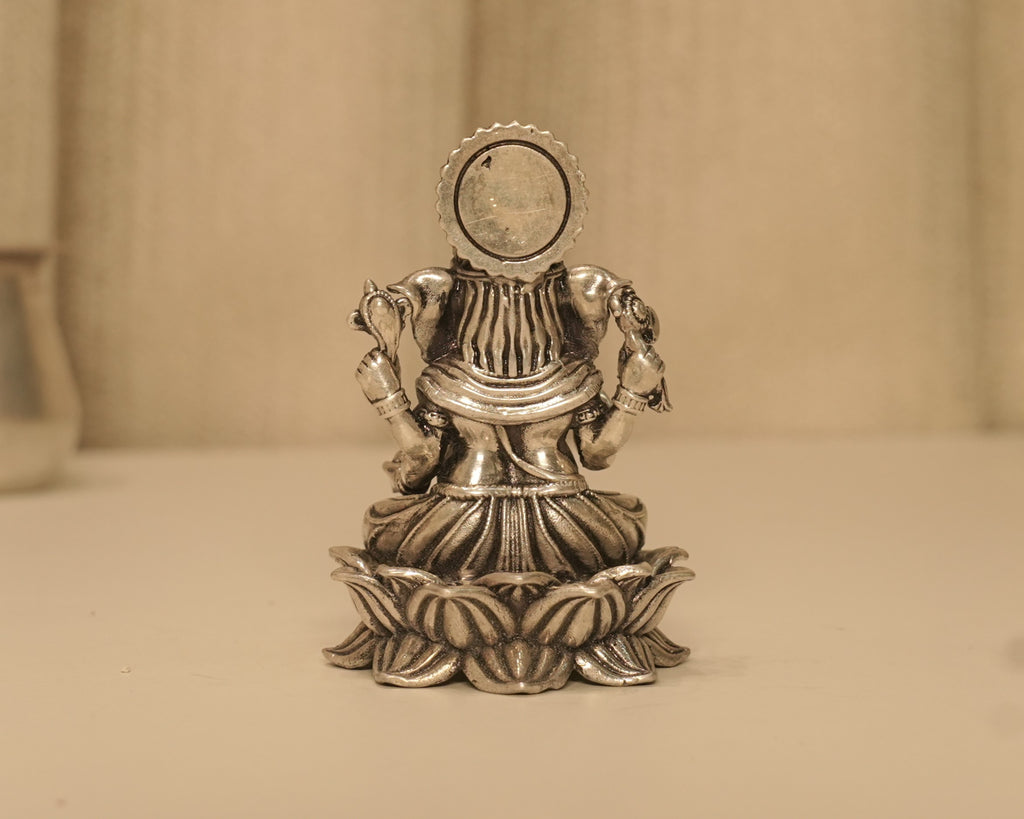 Back of the antique silver Ganesh idol, showing the plain round disc behind the crown.