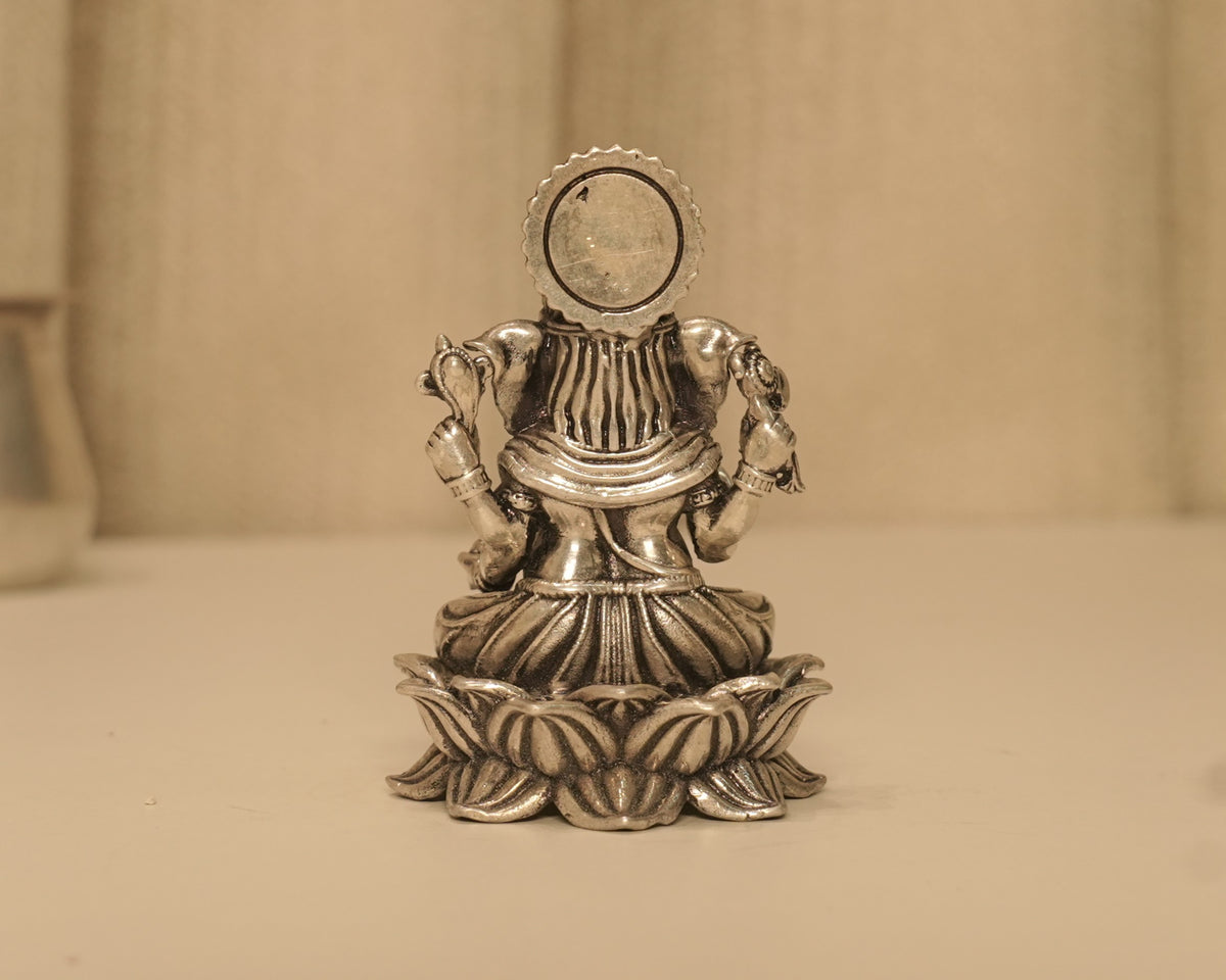 Back of the antique silver Ganesh idol, showing the plain round disc behind the crown.
