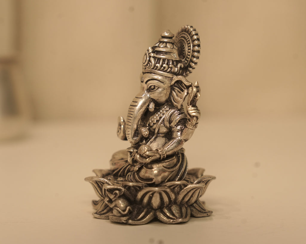 Side view of the antique silver Ganesh idol, showing the crown and the lotus base in profile.