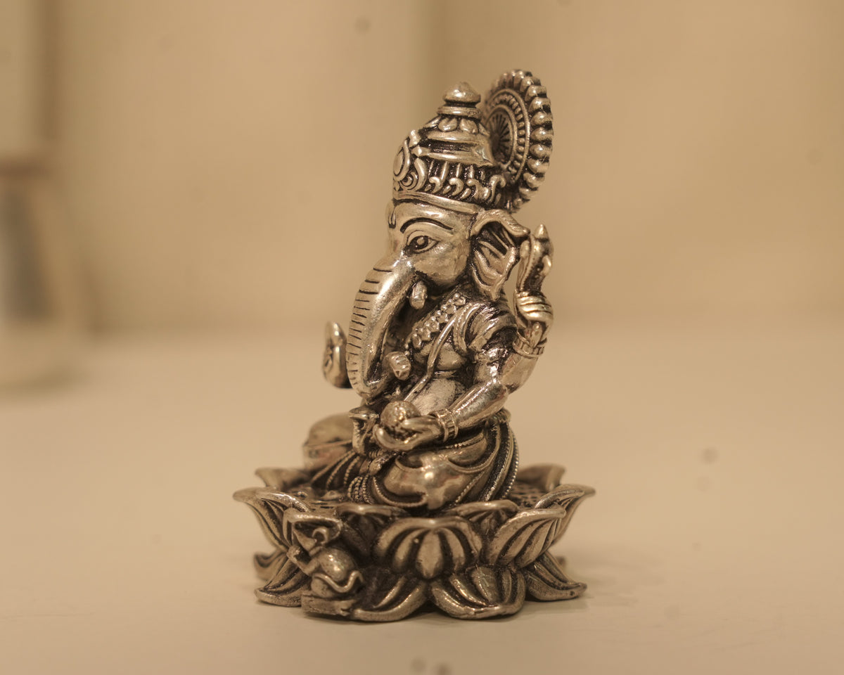 Side view of the antique silver Ganesh idol, showing the crown and the lotus base in profile.