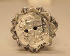 The open underside of the lotus base, showing the silver mark stamped into it.