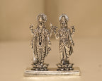 Sterling silver Vishnu and Lakshmi figures standing side by side on one long silver plinth.