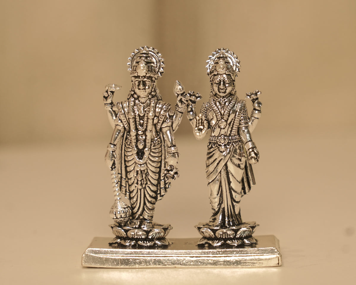 Sterling silver Vishnu and Lakshmi figures standing side by side on one long silver plinth.