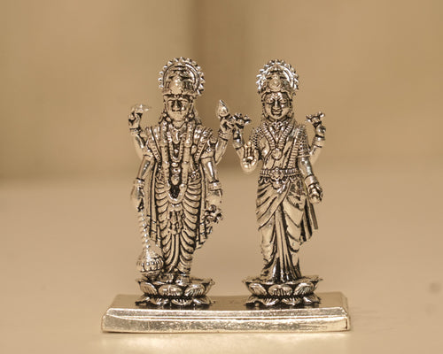 Sterling silver Vishnu and Lakshmi figures standing side by side on one long silver plinth.