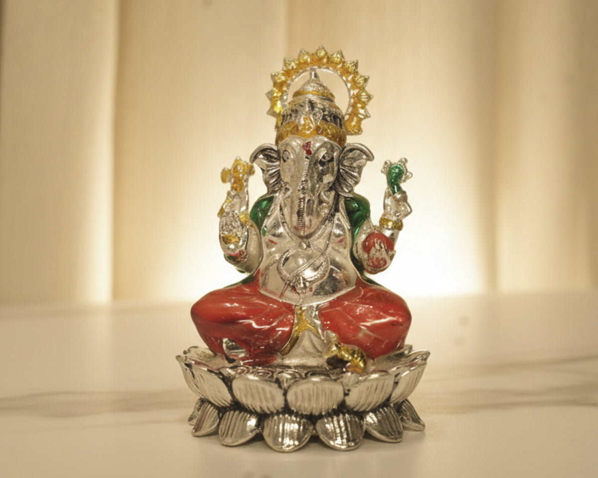 Large sterling silver Ganesh idol in a red enamel dhoti and green shawl, seated on a silver lotus base.