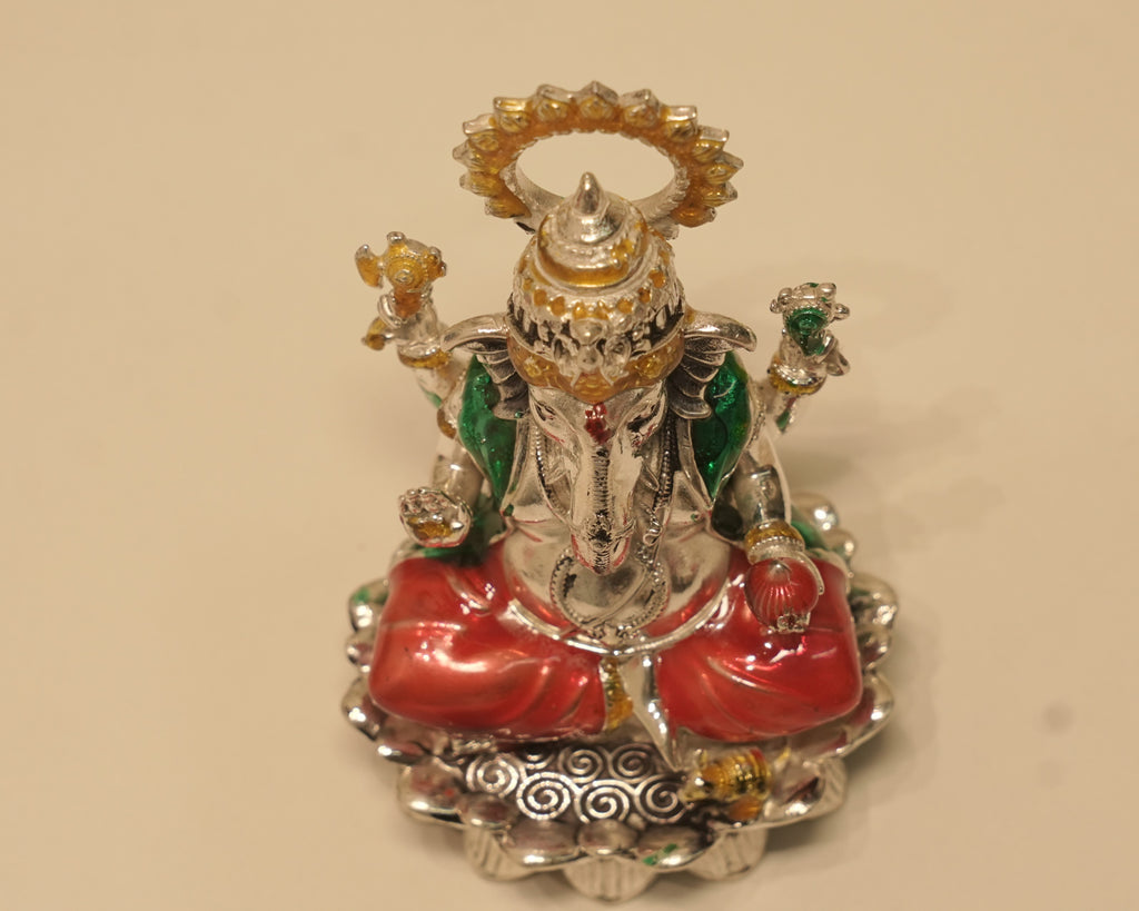 Looking down on the enamelled silver Ganesh idol, showing the scrolled border around the lotus rim.