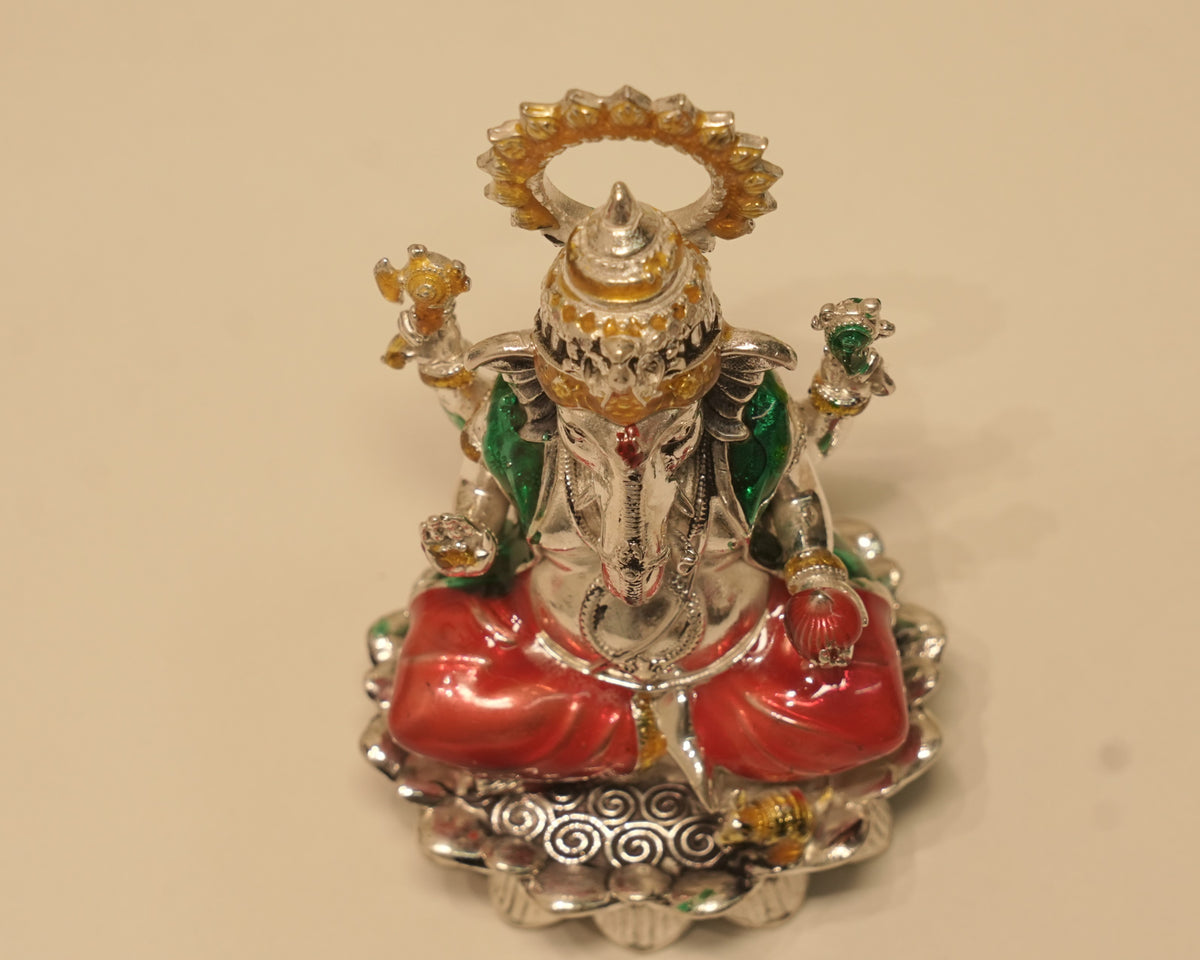 Looking down on the enamelled silver Ganesh idol, showing the scrolled border around the lotus rim.