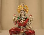 Close view of the enamelled silver Lakshmi figure, the gold enamel crown and the red and green robes.