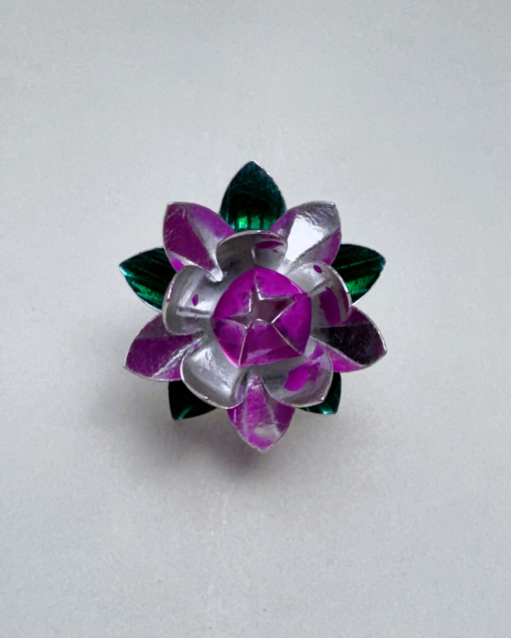 Sterling silver lotus flower seen from above, with deep pink enamel inner petals and green enamel leaves.