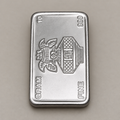 10 gram fine silver bar with a kalash and swastik on the face, stamped 10 gram 999 fine, on a beige surface.