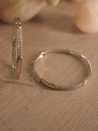 Pair of sterling silver bangles, one upright and one lying flat, with American Diamond rows catching the light.