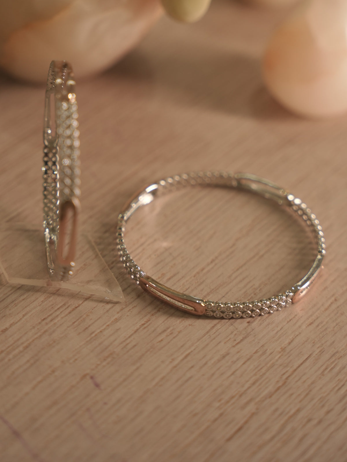 Pair of sterling silver bangles, one upright and one lying flat, with American Diamond rows catching the light.