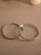 Side view of the American Diamond bangles, showing the bezel walls and the polished rose-tone stations.