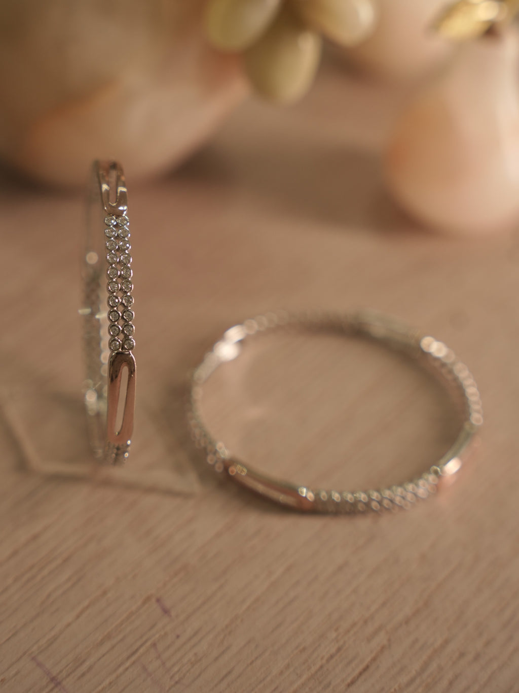 Both sterling silver bangles lying flat and overlapping, showing the even spacing of the stone rows.