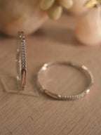 Both sterling silver bangles lying flat and overlapping, showing the even spacing of the stone rows.