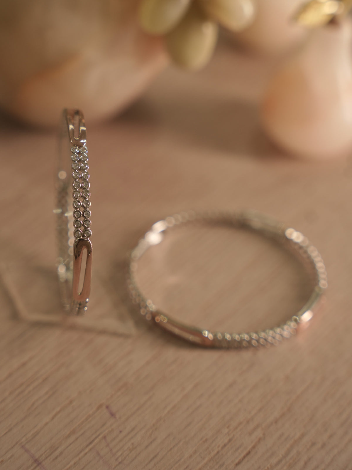 Both sterling silver bangles lying flat and overlapping, showing the even spacing of the stone rows.