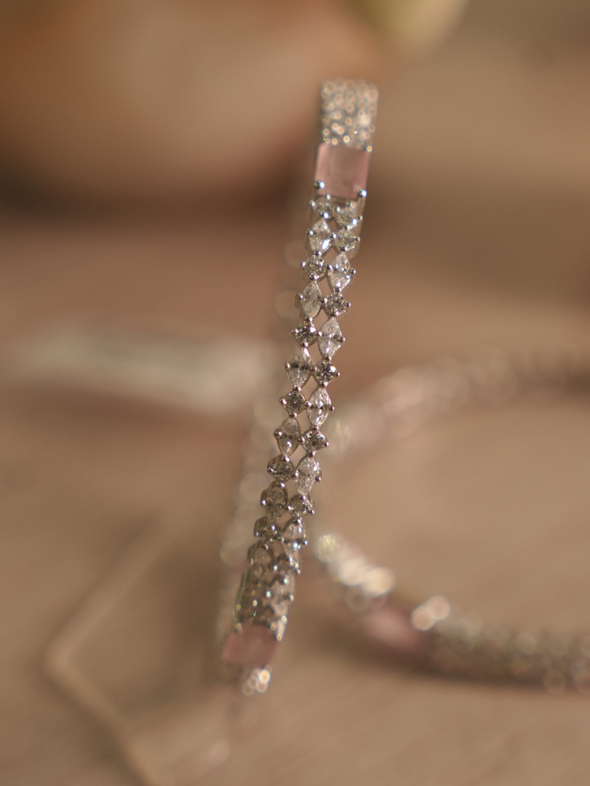 Close view of the bangle surface, with rows of small American Diamond around a flush set pink stone.