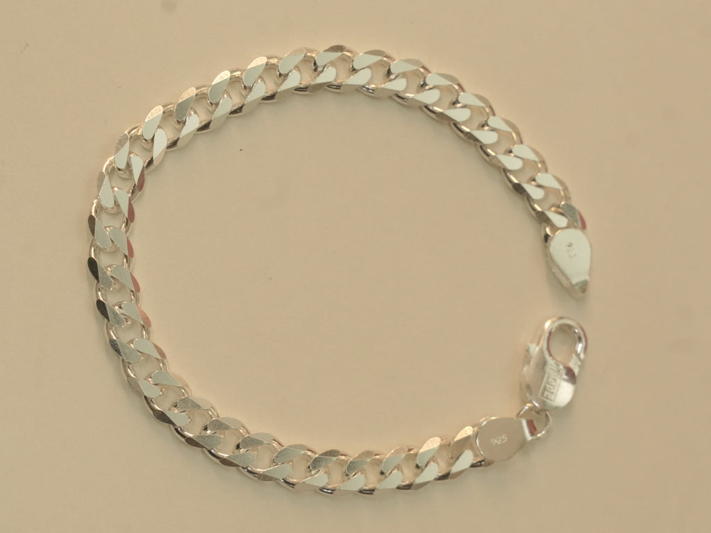 Sterling silver flat curb chain bracelet laid in a circle with the lobster clasp open.