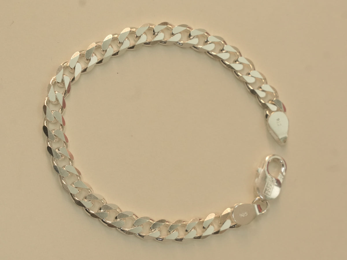 Sterling silver flat curb chain bracelet laid in a circle with the lobster clasp open.