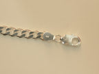 Close view of the lobster clasp and the end tab stamped 925 on the curb chain bracelet.