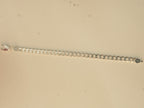 The curb chain bracelet laid out straight, showing its full length.